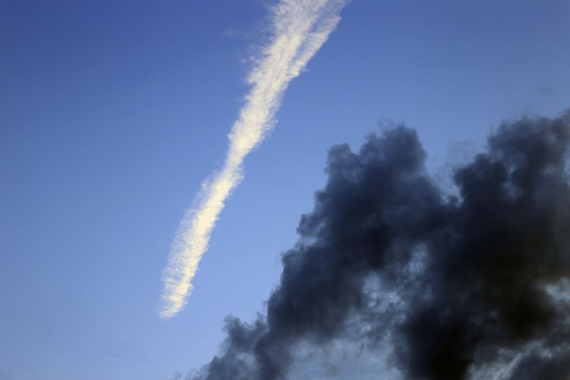 Foto, Kondensstreifen und dunkle Wolken vor klarem Himmel