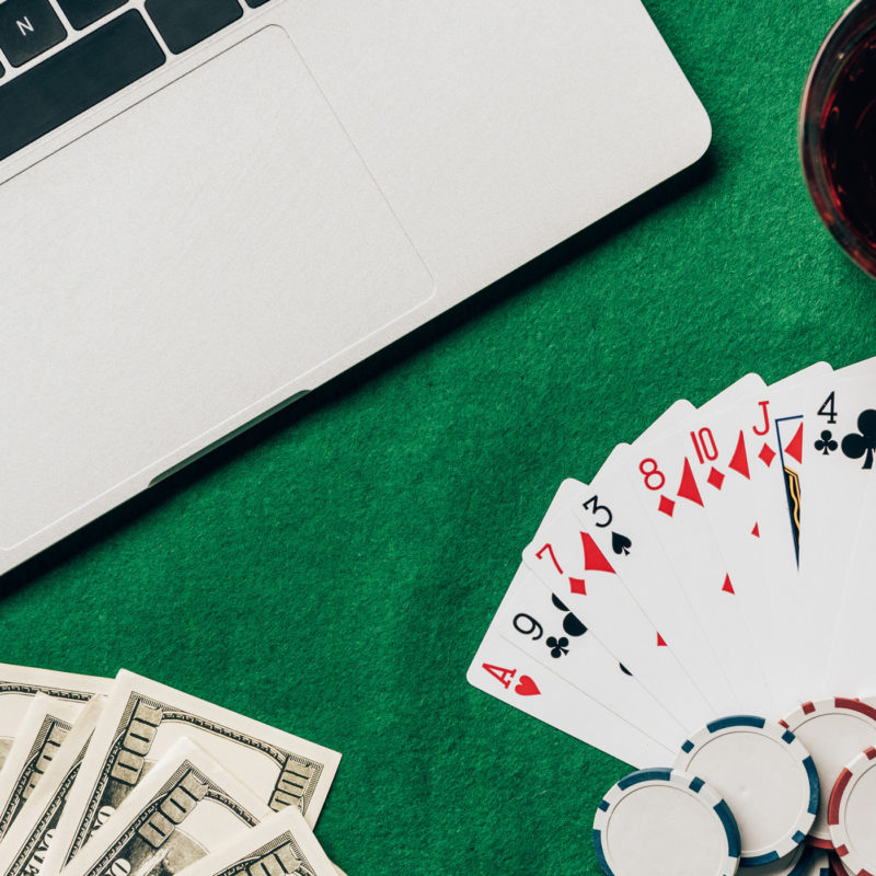 Laptop with dice and gambling chips on keyboard