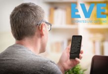 Ein Bild, drinnen, eine Person, sitzend, Mann von hinten mit Hörgerät und Brille auf das Handy schaut, indem er die Untertitel liest. In der rechten Encke oben befindet sich das Logo von EVE mit dem Text "EVE AUTOMATED LIVE CAPTIONS"