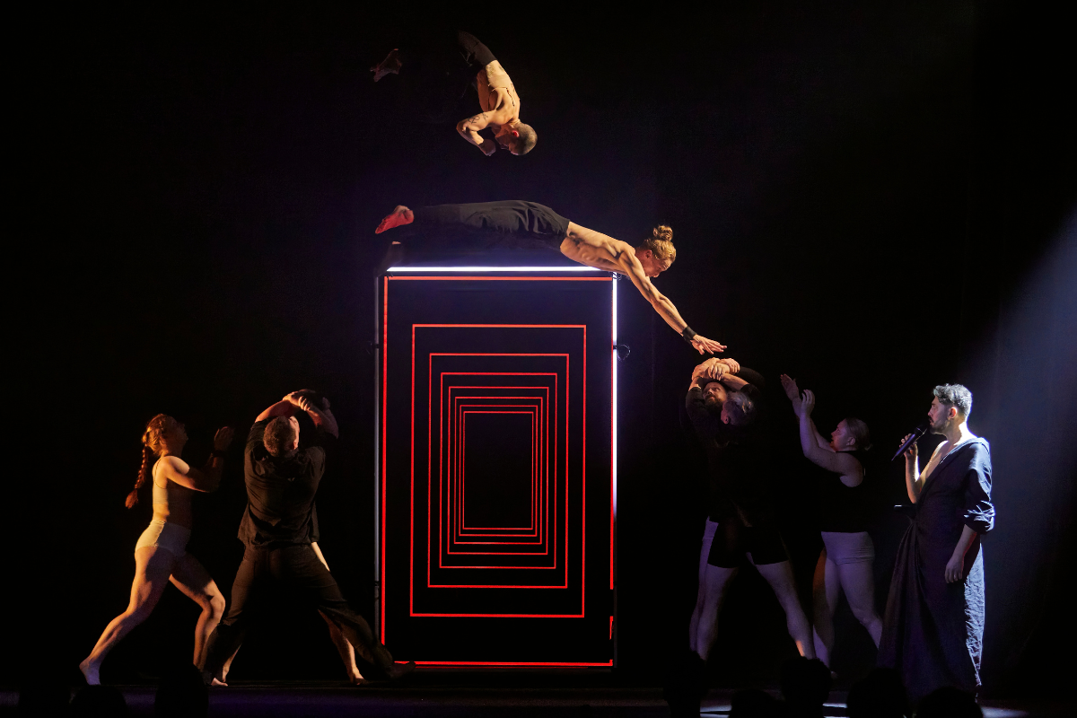 Die Akrobat:innen von The Mirror mitten im Sprung auf der Bühne.