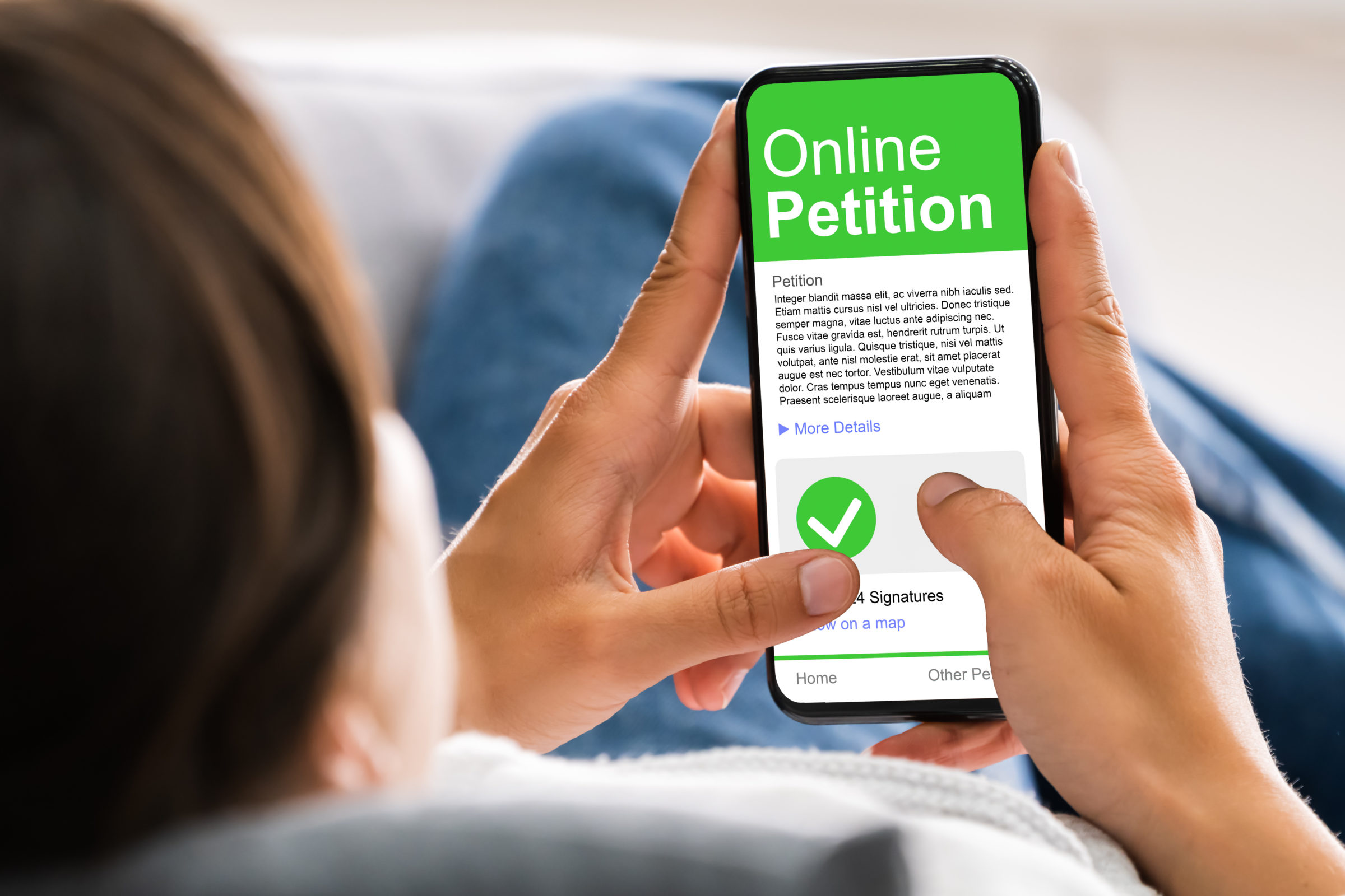 Person schaut auf ihren Smartphone-Bildungschirm und stimmt dort bei einer Online-Petition ab