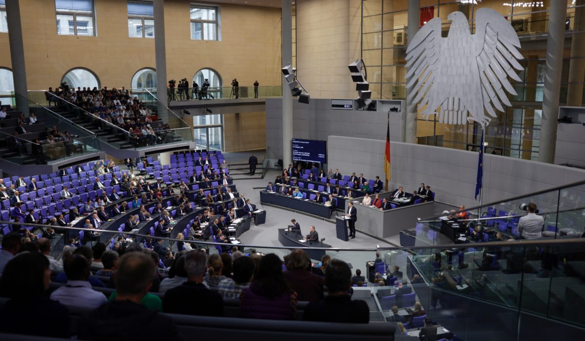 Blick von der Tribüne auf den Parlamentssaal. Rechts der Bundesadler an der Wand.