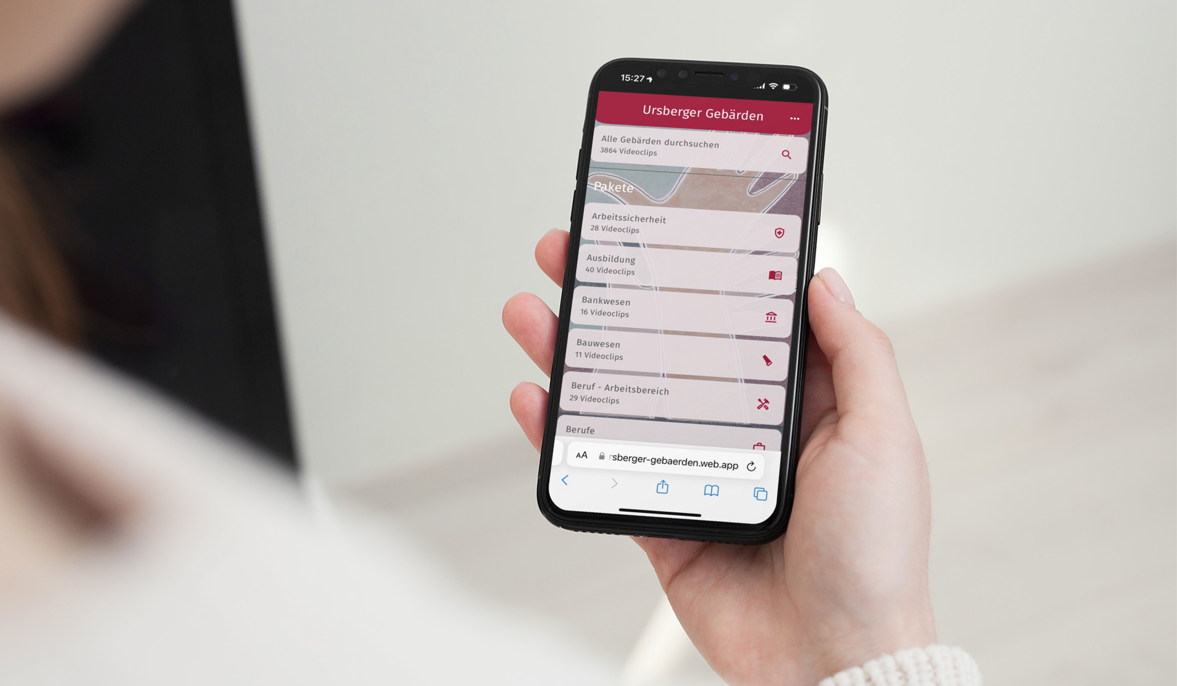 Eine Person hält ein Handy, auf dem die Auswahl der Ursberger Gebärden-App zu sehen ist