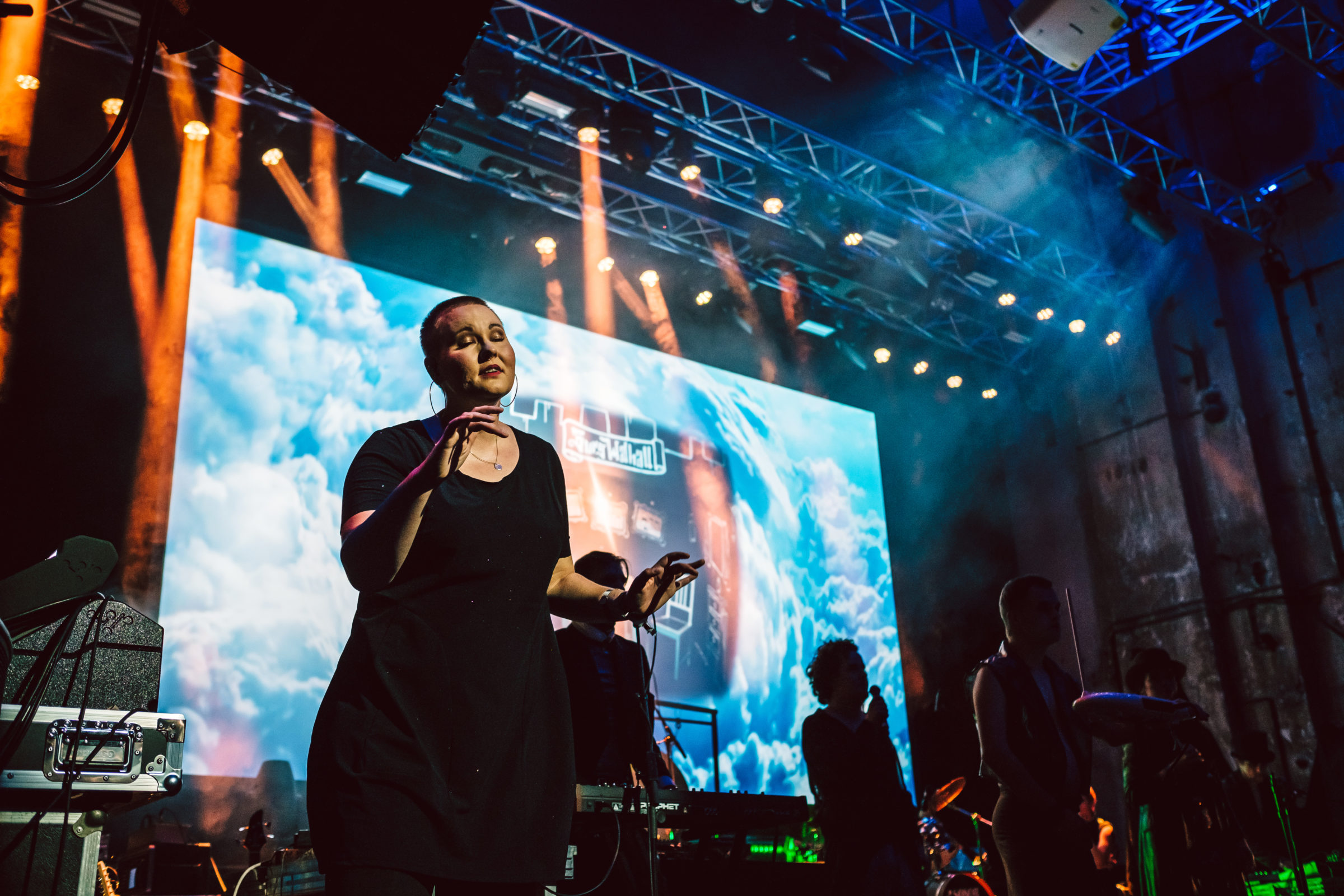 Laura Maaß steht auf der Bühne, im Hintergrund ein Konzert