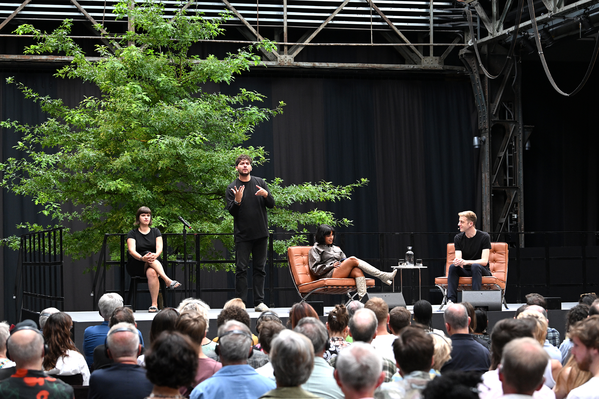 Podiumsgespräch mit DGS-Dolmetscher auf der Bühne bei Brave New Voices in der Jahrhunderthalle Bochum, vor großem Publikum.