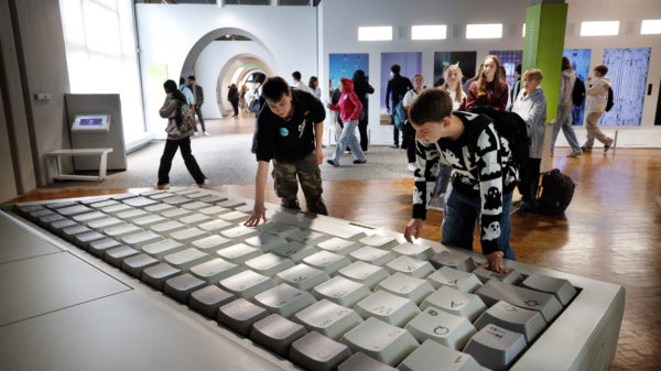 Jugendliche vor einem großen Laptop in der DASA