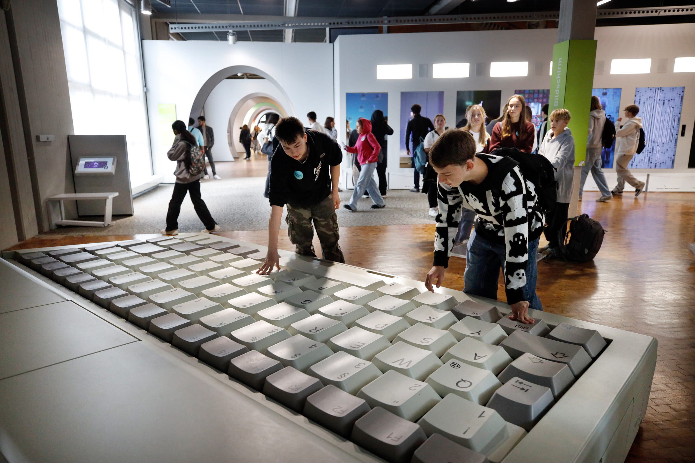 Jugendliche vor einem großen Laptop in der DASA
