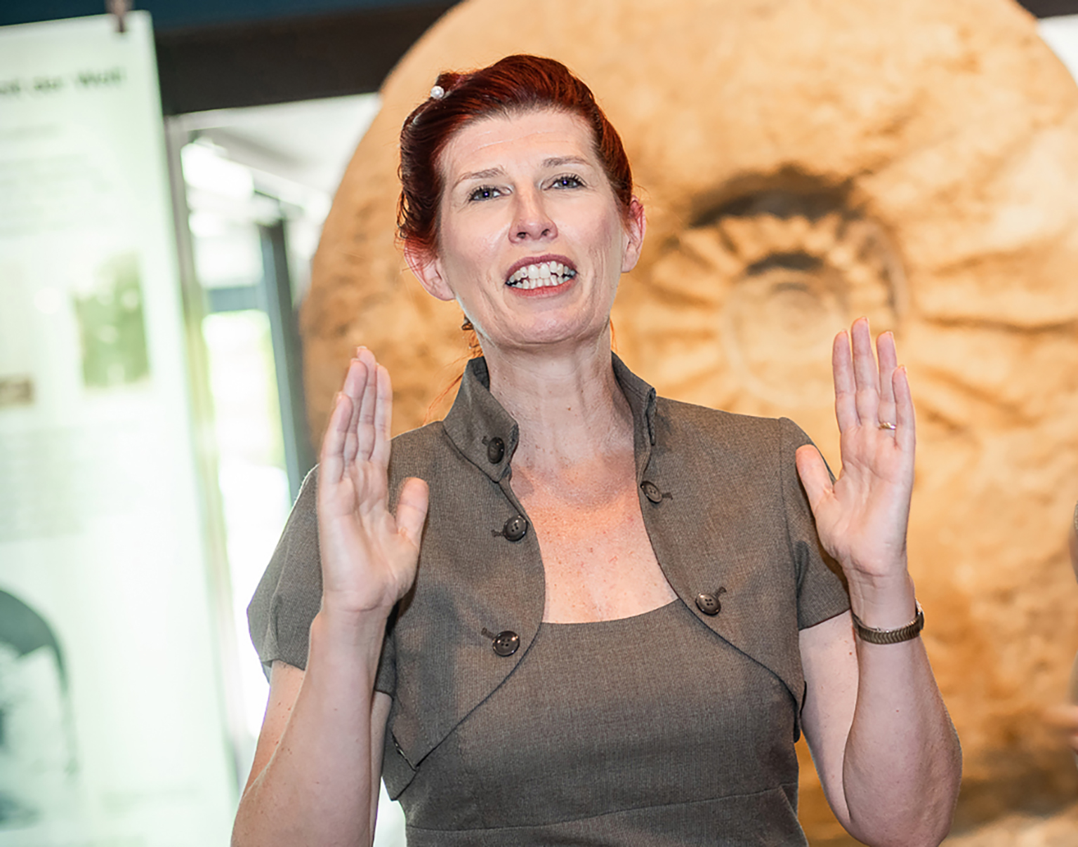 Dolmetscherin Alexandra Lorenz beim Gebärden vor dem Fossil des Riesenammoniten im LWL-Museum für Naturkunde.